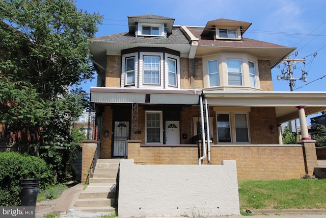 view of front facade featuring brick siding and covered porch