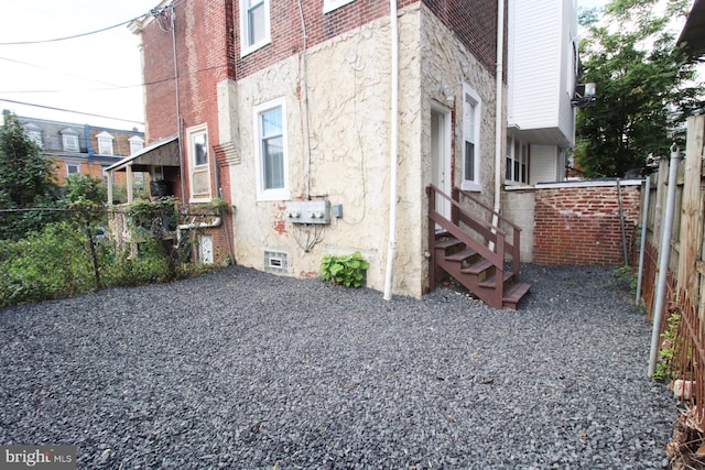 view of home's exterior with stone siding and fence
