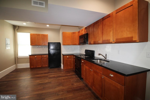 kitchen featuring baseboards, visible vents, a sink, black appliances, and dark wood-style floors