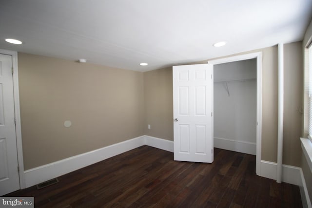 unfurnished bedroom featuring a closet, visible vents, baseboards, dark wood-type flooring, and recessed lighting