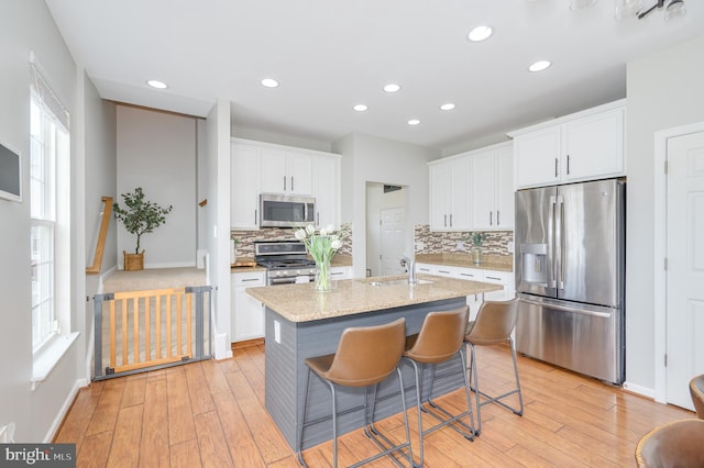 109 Manila Pl, Stephenson, VA 22656 - kitchen with appliances with stainless steel finishes, decorative backsplash, light wood finished floors, white cabinets, and recessed lighting