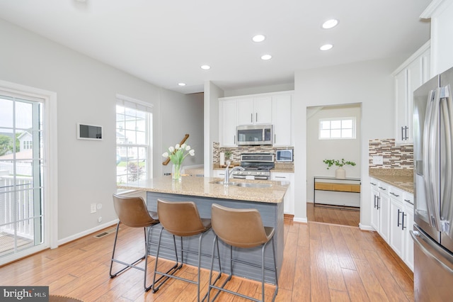 109 Manila Pl, Stephenson, VA 22656 - kitchen with appliances with stainless steel finishes, backsplash, light wood-style flooring, white cabinets, and recessed lighting
