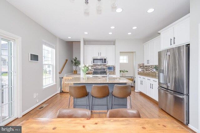109 Manila Pl, Stephenson, VA 22656 - kitchen with stainless steel appliances, tasteful backsplash, white cabinets, recessed lighting, and light wood-style floors
