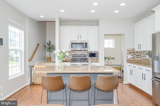 109 Manila Pl, Stephenson, VA 22656 - kitchen with stainless steel appliances, a sink, decorative backsplash, a breakfast bar, and recessed lighting