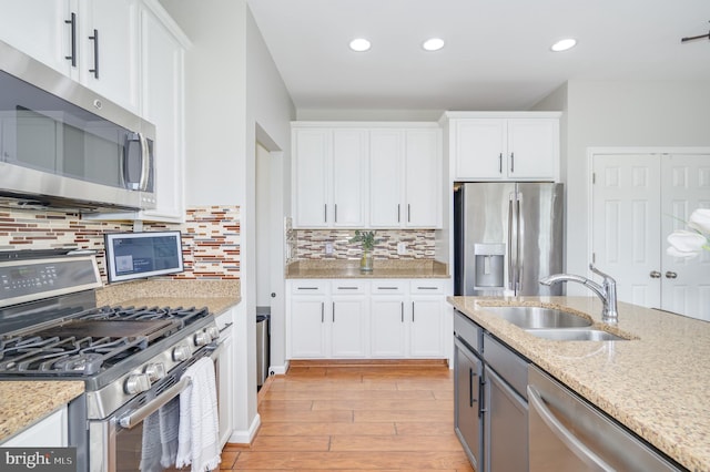 109 Manila Pl, Stephenson, VA 22656 - kitchen featuring appliances with stainless steel finishes, a sink, light wood-style flooring, white cabinets, and light stone countertops