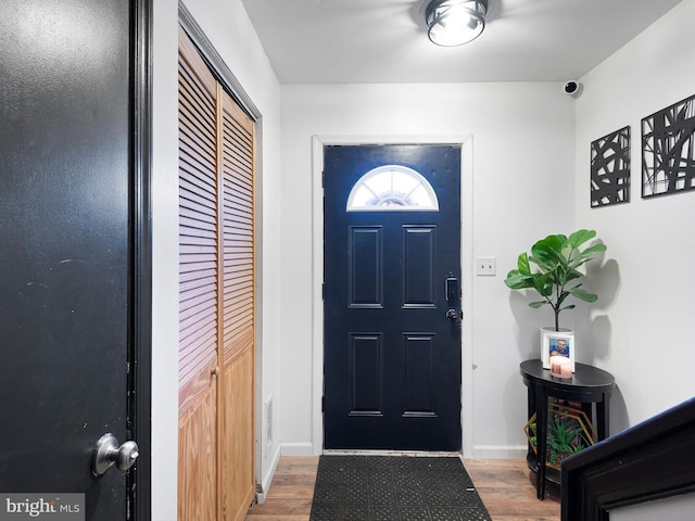 foyer with baseboards and wood finished floors