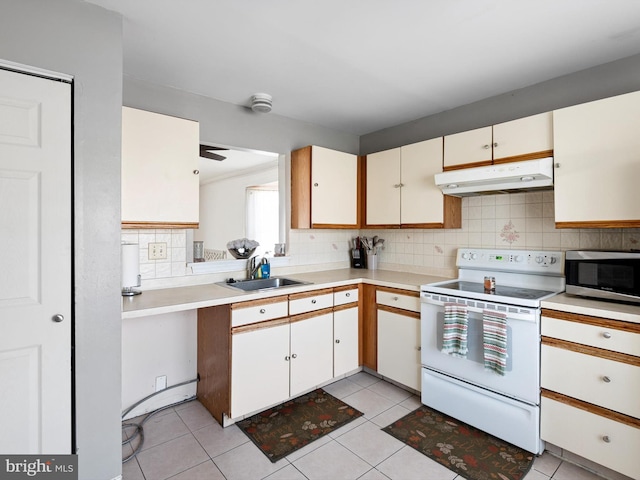 kitchen with white electric range oven, stainless steel microwave, under cabinet range hood, tasteful backsplash, and a sink