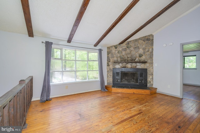 unfurnished living room with a fireplace, baseboards, lofted ceiling with beams, and hardwood / wood-style flooring