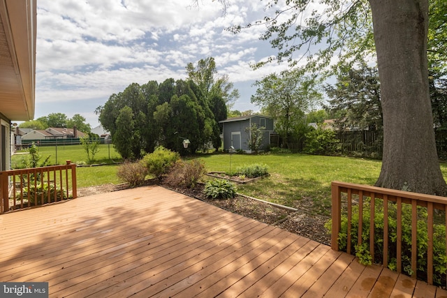 deck featuring a fenced backyard, an outbuilding, and a yard