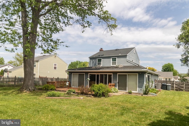 rear view of property featuring fence, a chimney, a yard, and a shingled roof