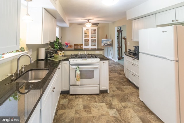 kitchen featuring a ceiling fan, stone finish flooring, a sink, white appliances, and white cabinetry