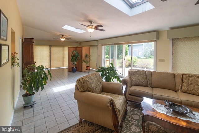 living room with light tile patterned floors, baseboards, a ceiling fan, and lofted ceiling with skylight
