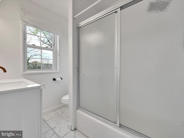 bathroom featuring baseboards, vanity, toilet, shower / bath combination with glass door, and marble finish floor