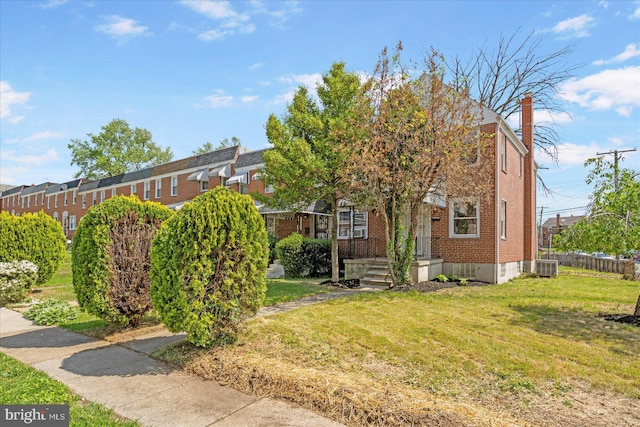 exterior space featuring brick siding, a lawn, central air condition unit, and a chimney