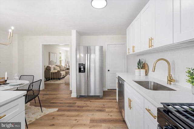 577 Lucia Ave, Baltimore, MD 21229 - kitchen with a sink, light countertops, light wood-style flooring, stainless steel appliances, and white cabinetry