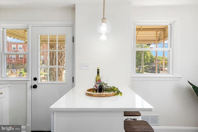 interior space featuring baseboards, visible vents, and a wealth of natural light