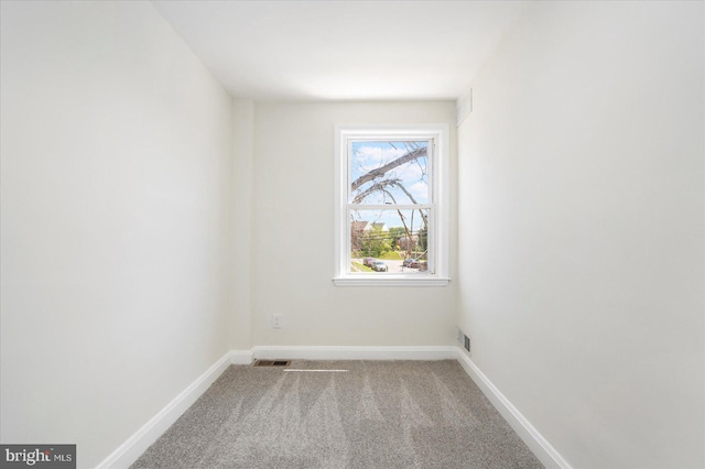 carpeted spare room with baseboards and visible vents