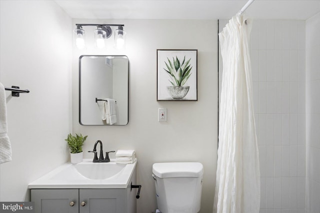 full bathroom with vanity, toilet, and tiled shower