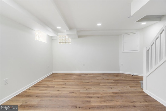 below grade area featuring light wood finished floors, recessed lighting, and stairs