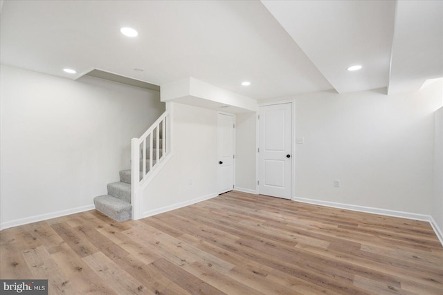finished below grade area with baseboards, recessed lighting, and wood finished floors