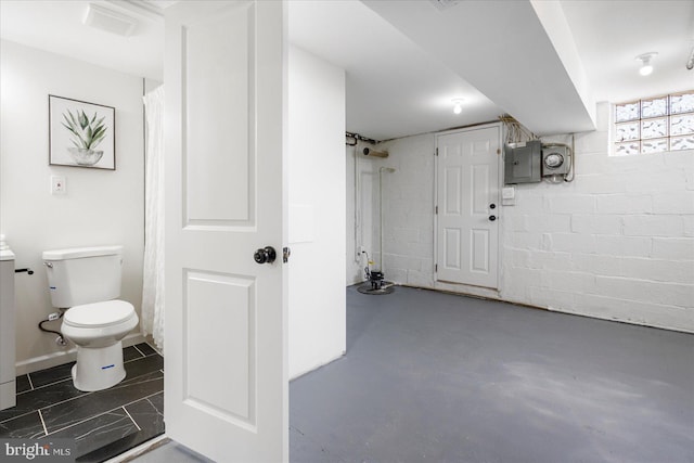 full bath featuring toilet, concrete floors, and electric panel