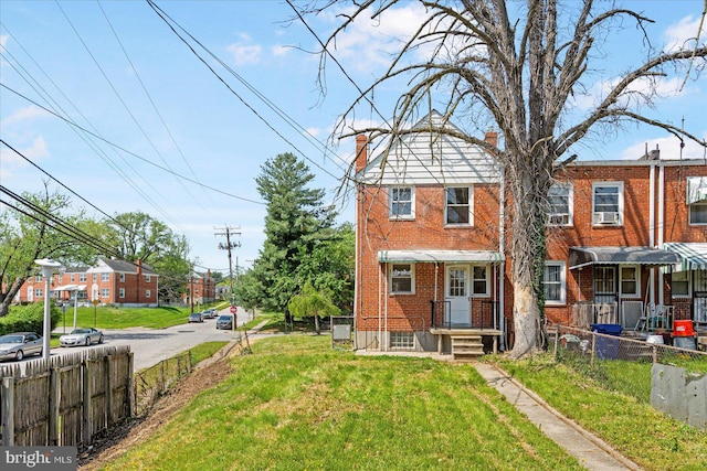577 Lucia Ave, Baltimore, MD 21229 - view of front of property with brick siding, a chimney, a front yard, and fence private yard