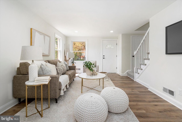 living area with visible vents, stairs, wood finished floors, baseboards, and recessed lighting