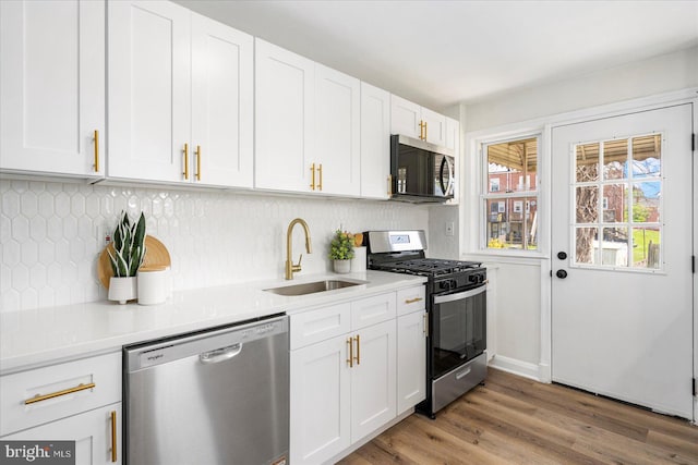 kitchen featuring a sink, light countertops, white cabinets, and stainless steel appliances