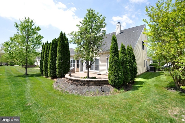 view of yard with central AC unit and a patio area