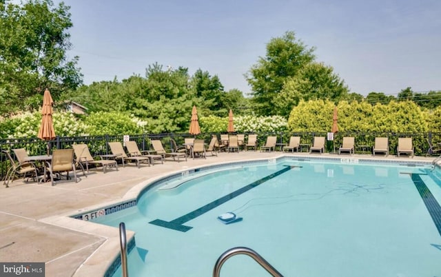 pool featuring fence and a patio area