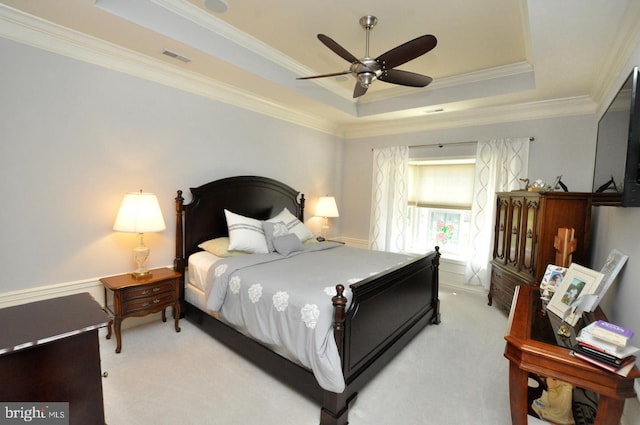 bedroom featuring a raised ceiling, ornamental molding, light carpet, and visible vents
