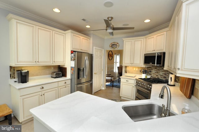 kitchen featuring ceiling fan, cream cabinets, a sink, light countertops, and stainless steel appliances