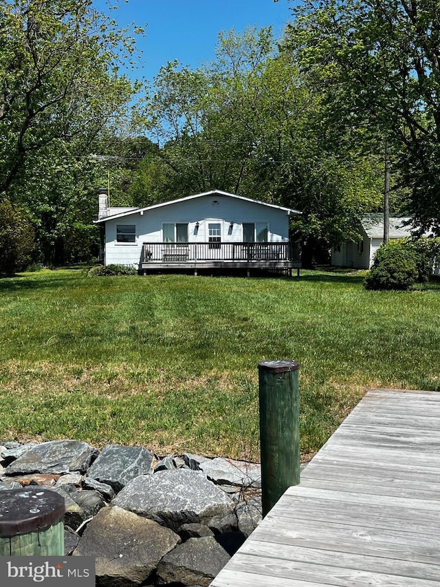 back of house with a yard, a deck, and a chimney