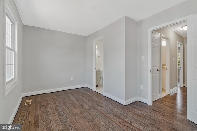 unfurnished bedroom with multiple windows, wood finished floors, and visible vents