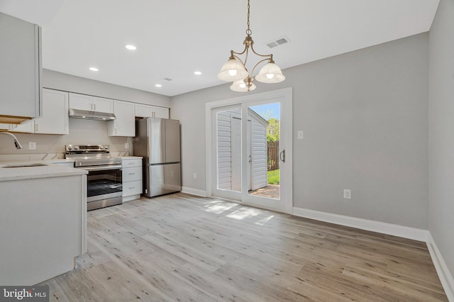 kitchen featuring visible vents, baseboards, under cabinet range hood, a sink, and appliances with stainless steel finishes