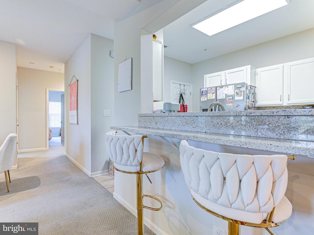1720 Lake Shore Crest Dr Unit 35, Reston, VA 20190 - kitchen with freestanding refrigerator, light colored carpet, light stone counters, white cabinets, and baseboards