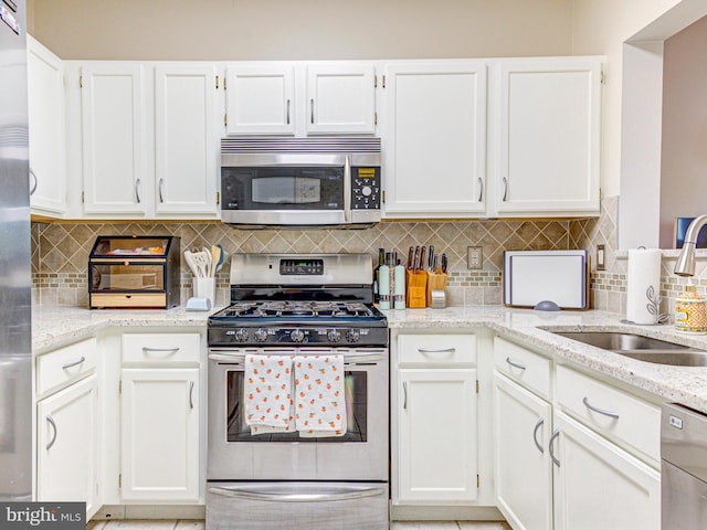 1720 Lake Shore Crest Dr Unit 35, Reston, VA 20190 - kitchen featuring white cabinets, stainless steel appliances, light stone counters, and a sink