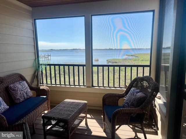 sunroom featuring a water view