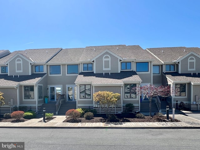 townhome / multi-family property featuring roof with shingles