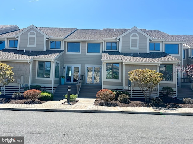 multi unit property with french doors, stairs, and roof with shingles
