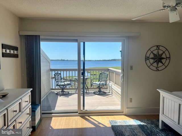 doorway with plenty of natural light, dark wood finished floors, and a water view