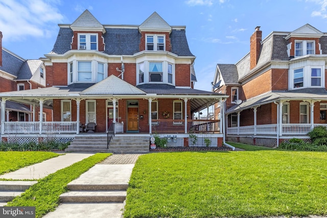 541 Madison Ave, York, PA 17404 - view of front of home with a porch, brick siding, mansard roof, and a front lawn
