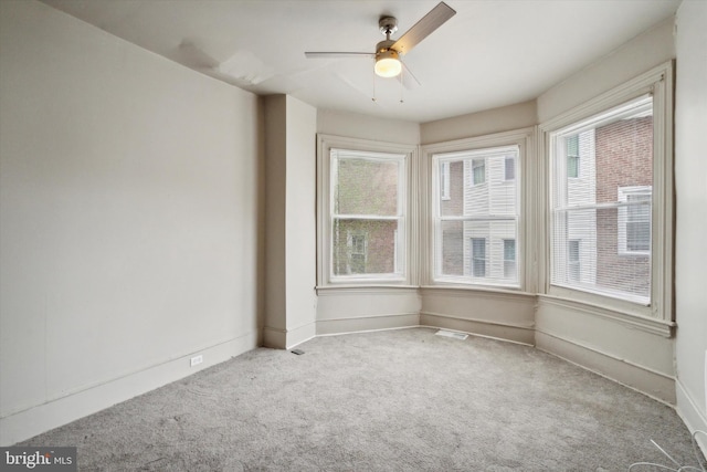 unfurnished room featuring a ceiling fan, baseboards, visible vents, and carpet