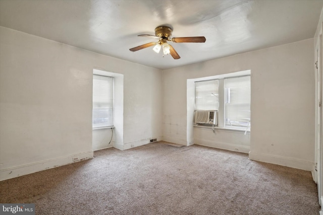 spare room featuring carpet floors, baseboards, cooling unit, and a ceiling fan