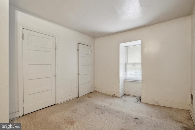 unfurnished bedroom featuring baseboards and carpet