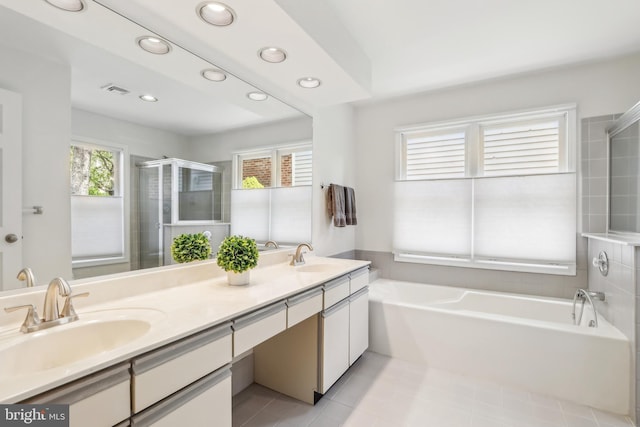 bathroom featuring a stall shower, recessed lighting, a bath, double vanity, and tile patterned floors