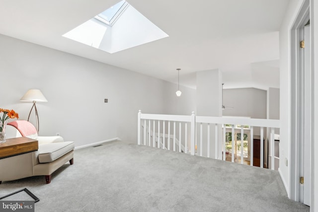 sitting room featuring carpet, a skylight, and vaulted ceiling