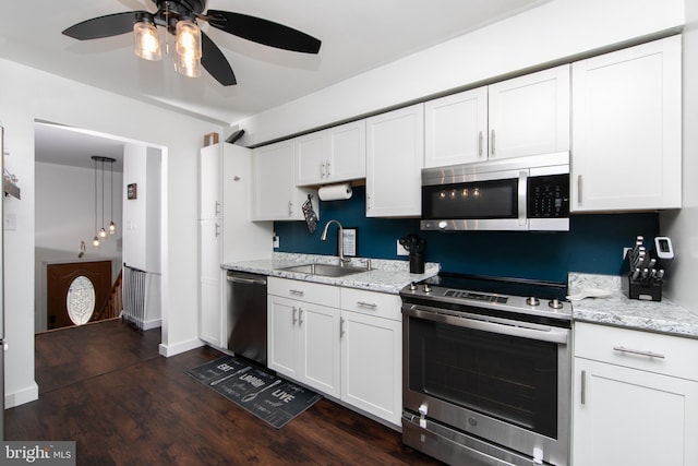 kitchen featuring a ceiling fan, dark wood-style flooring, a sink, stainless steel appliances, and white cabinetry