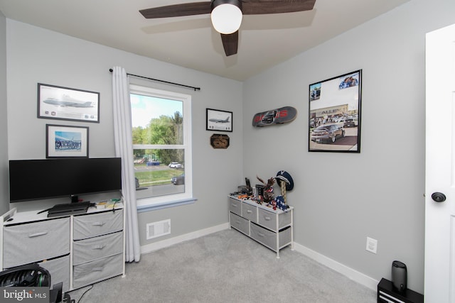 home office with a ceiling fan, light colored carpet, visible vents, and baseboards