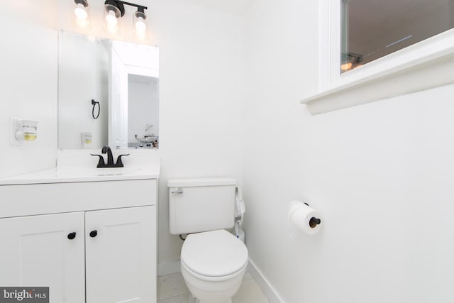 half bathroom with toilet, baseboards, tile patterned flooring, and vanity